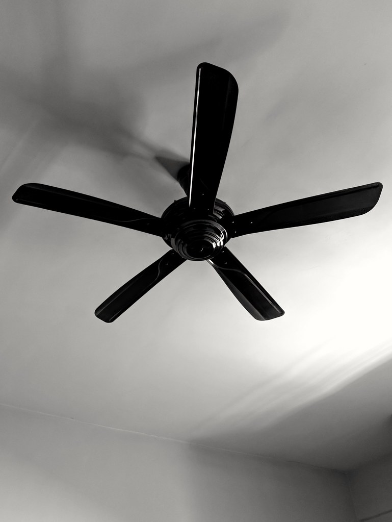 Ventilador de teto em movimento representa simbolicamente a mente acelerada e o pensamento circulante que impede o sono.