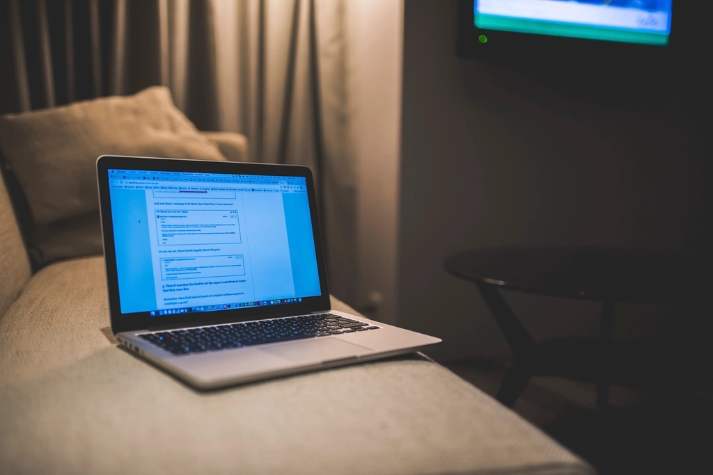 Notebook aberto sobre uma mesa de home office com a tela de uma videochamada