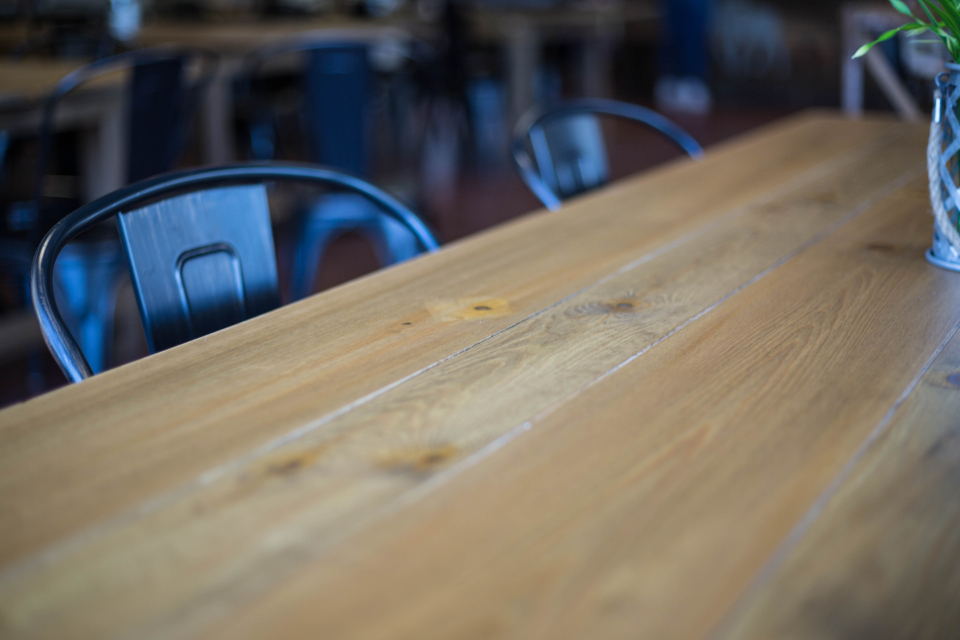 Mesa de bar com copos e luzes suaves à noite, sem pessoas