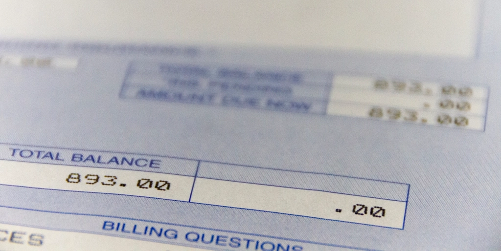 Extrato bancário aberto sobre mesa ao lado de calculadora e contas, representando o momento de confronto com as finanças