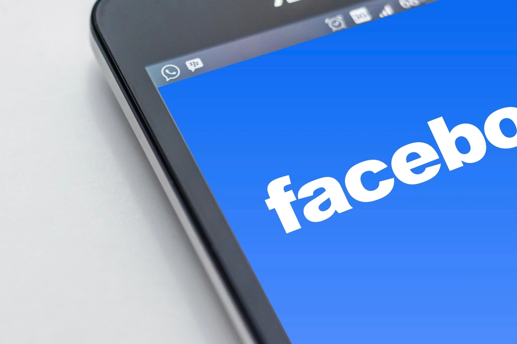 Smartphone exibindo o logo do Facebook, representando visualmente a ansiedade gerada por notificações e chamadas em rede