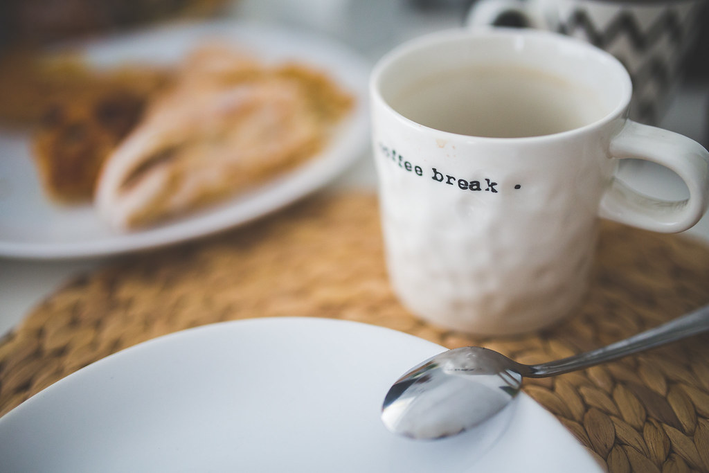 Cena acolhedora de café da manhã com xícara e prato ao fundo que simboliza o momento presente que a ansiedade pode rouba