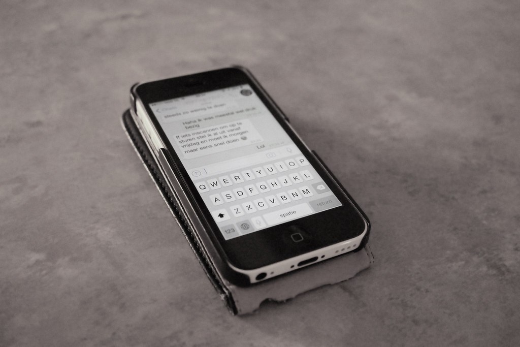 Smartphone com teclado visível e mensagens na tela ilustra perfeitamente a ansiedade de esperar respostas em comunicaçõe